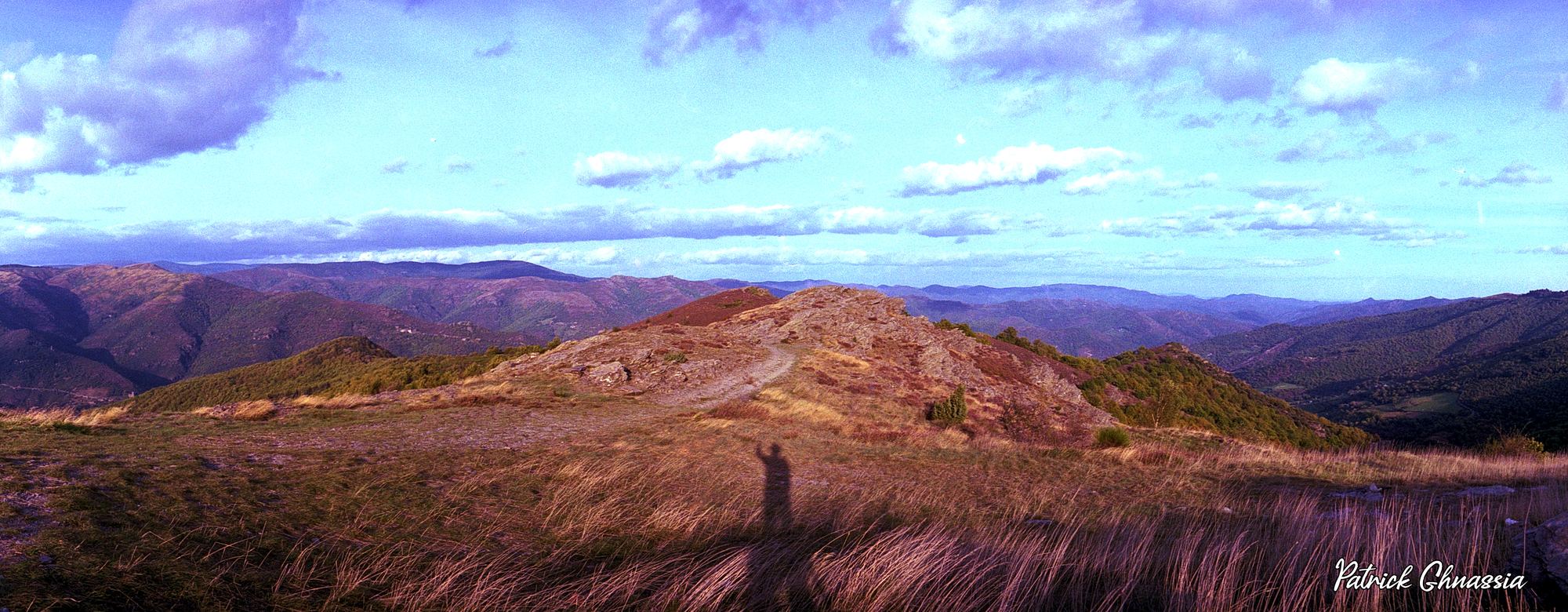 Panoramique des Cévennes, la Corniche — l’ombre portée du photographe s’allonge sur le paysage. Photographie de Patrick Ghnassia.